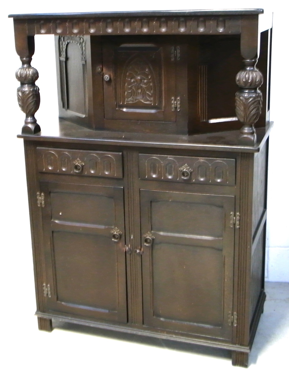 A dark oak priory style cabinet, height 129cm and a matching priory court cupboard, 135 x 92cm (2).