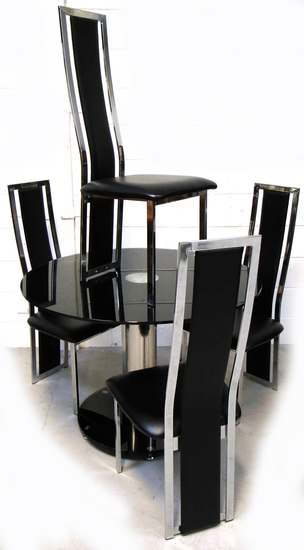 A modern black glass and chromed dining table, width 105cm,