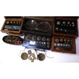 Seven cased sets of miniature balance scales and a sets of weights.