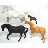 Four assorted Beswick horse figurines to include a grey shire horse, a black stallion and a foal,