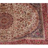 A beige ground Keshan carpet, the central floral motif surrounded by a border of floral sprays,