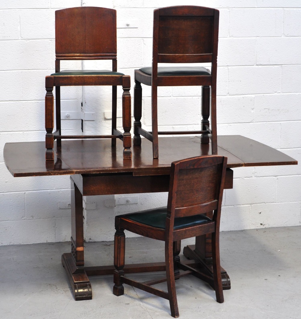 An early 20th century oak extending dining table with part carved supports,