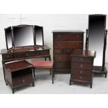 A Stag Minstrel part bedroom suite comprising a dressing table and stool, low bedside unit,