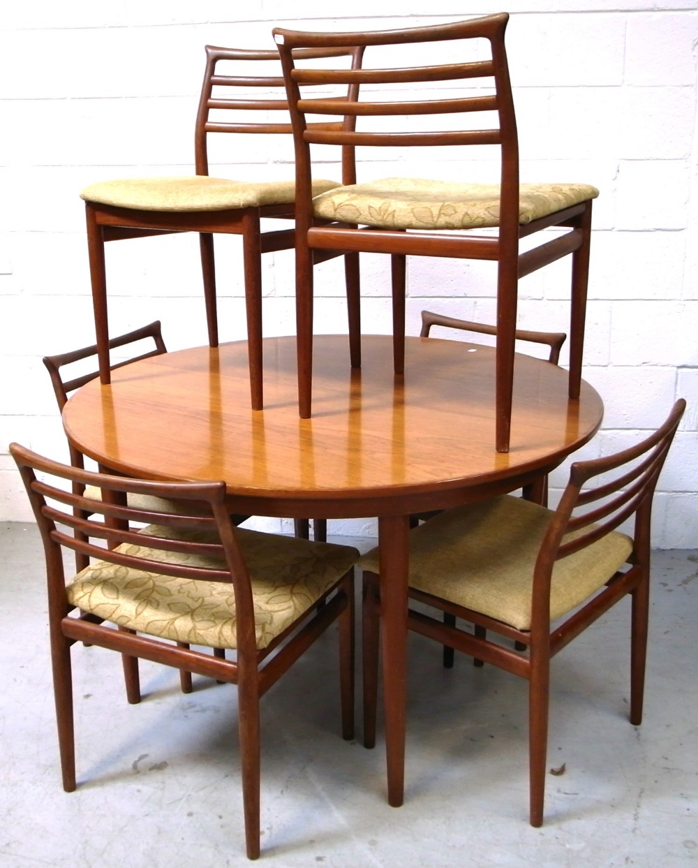 A retro G Plan extending dining table with two spare leaves and a set of six matching chairs,