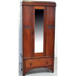 A mahogany single door wardrobe, glazed central door above lower drawer and bracket feet,