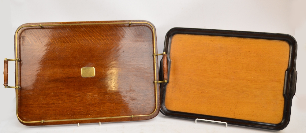 An oak twin handled rounded rectangular tray with brass gallery and central plaque,