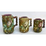 Three Victorian graduated majolica jugs, with painted and moulded floral and foliate decoration,