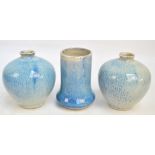 A pair of Cobridge high fired glazed stoneware vases decorated in mottled shades of blue and white,