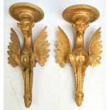 A near pair of 19th century Italian gilt wood wall brackets carved as gargoyles, both bearing an old