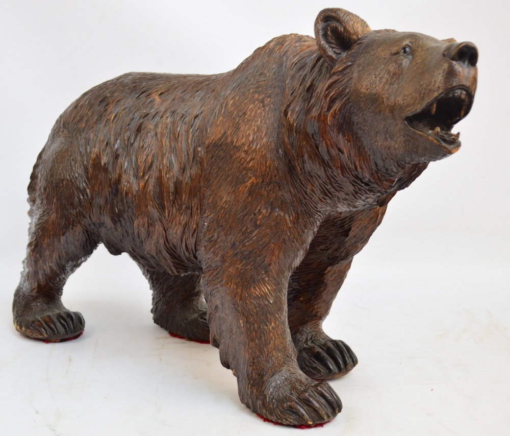 A large late 19th century Black Forest carved figure of a bear standing four square with open