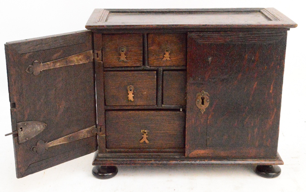 An 18th century oak spice cabinet, the rectangular moulded top above twin cupboard doors enclosing