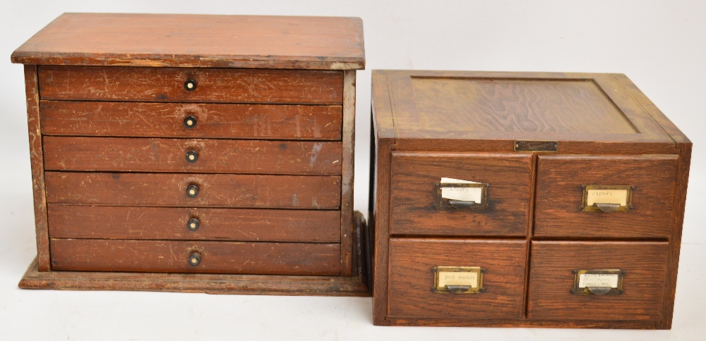 A small stained pine collector's/tool cabinet with six shallow drawers, raised on shaped plinth,