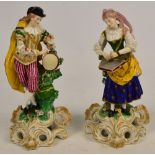 A pair of early 19th century Derby figures of musicians, he wearing pink and red striped breeches