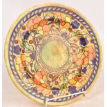 CHARLOTTE RHEAD; a tube lined decorative charger painted in autumnal colours, painted marks to
