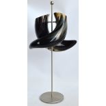 An unusual double section cow horn vase raised on brushed steel stand, height 70cm.