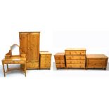 A seven piece pine bedroom suite comprising a double wardrobe, a mirror back dressing table,