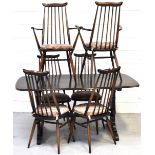 An Ercol dining suite comprising dark oak table and six matching stick back chairs (4+2),