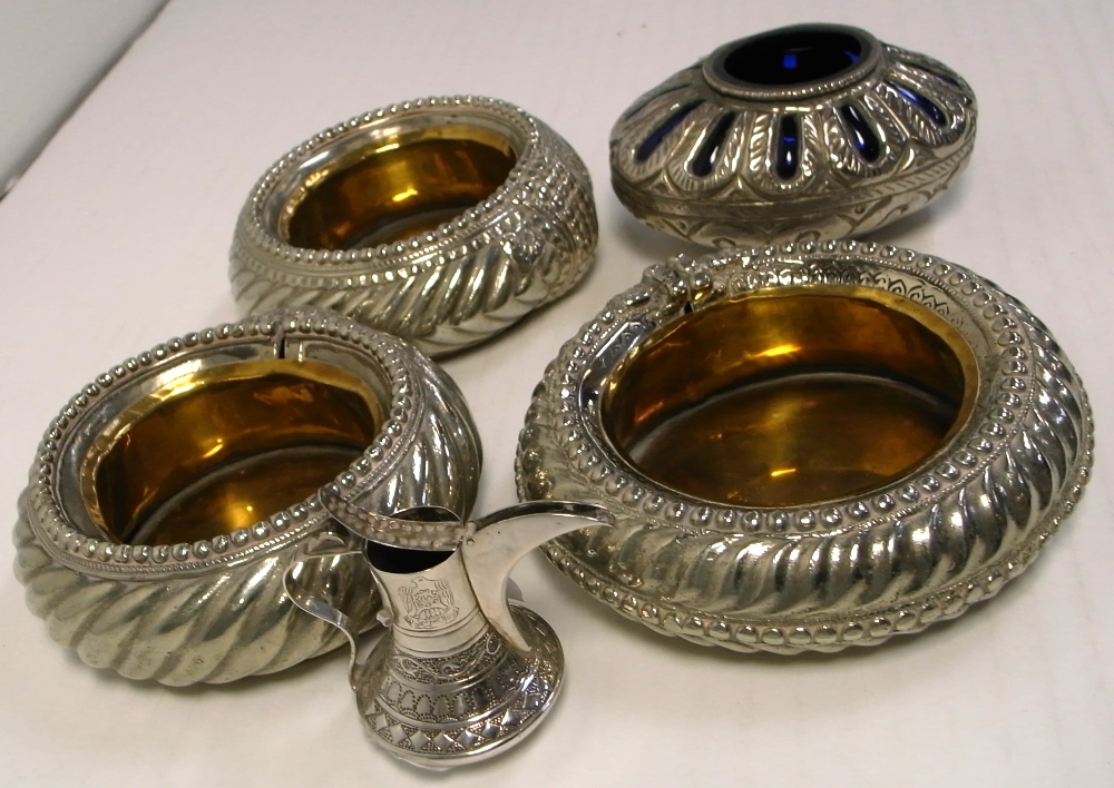 Three brass and white metal Middle Eastern bowls and a blue glass bowl with white metal overlay,