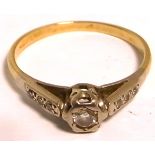 A gold illusion set diamond ring with small diamond chips to the shoulders, size O 1/2,