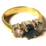 A yellow metal ring set with a central blue topaz and diamond either side, size H, approx weight 3.