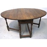 An 18th century oak gateleg table with ring turned supports terminating in block supports,