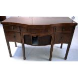 A 19th century mahogany serpentine front sideboard with five drawers and a tambour door section on