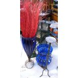 Three large ornamental glass vases on metal stands,