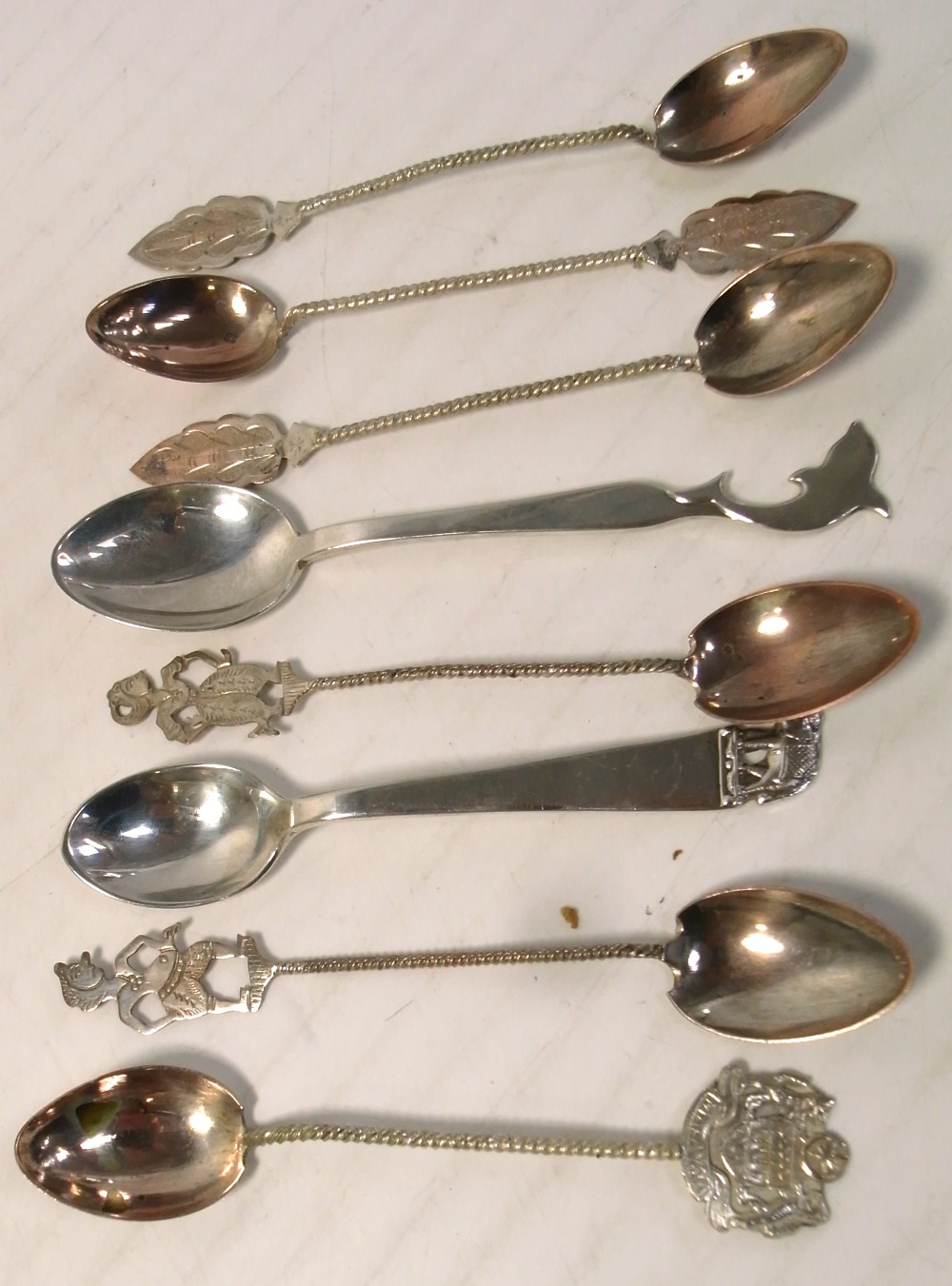 A cased set of six teaspoons with wrythen handles and various finials to include an Indian dancing
