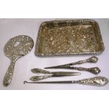 A white metal tray, two pairs of glove stretchers, a hand mirror and a button hook,