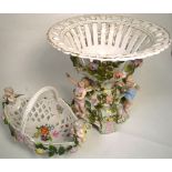 A Continental centrepiece, pierced basket top above three cherubic like figures with florally