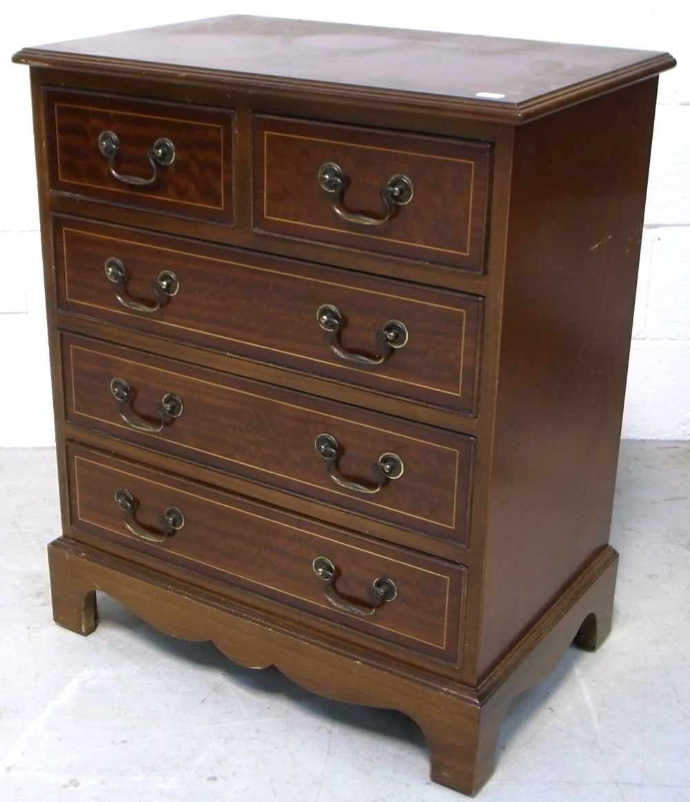 A mahogany and inlaid two over three chest of drawers of small proportions with brass handles on