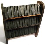 A miniature wooden bookcase containing thirty six leather bound miniature books,