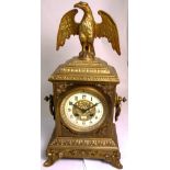 A late 19th early 20th century French gilded clock with eagle decoration to the top on a stacked