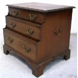 A late 19th early 20th century oak three drawer chest of drawers of stepped design and small