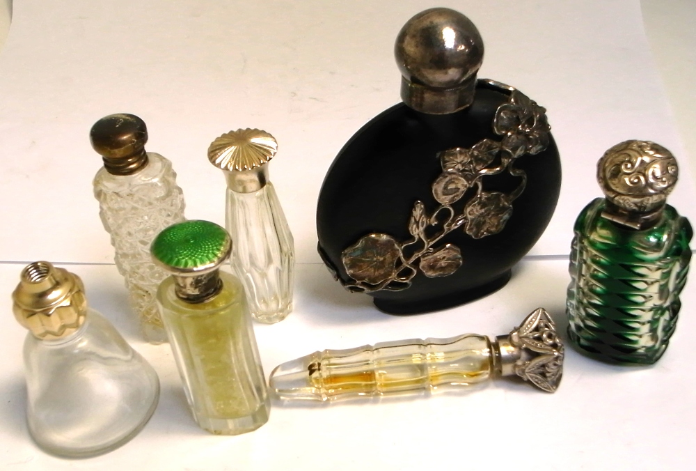 A quantity of scent bottles with hallmarked silver and white metal lids, various hallmarks.