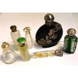 A quantity of scent bottles with hallmarked silver and white metal lids, various hallmarks.