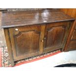 A 19th century oak two door cabinet of small proportions raised on square section supports,