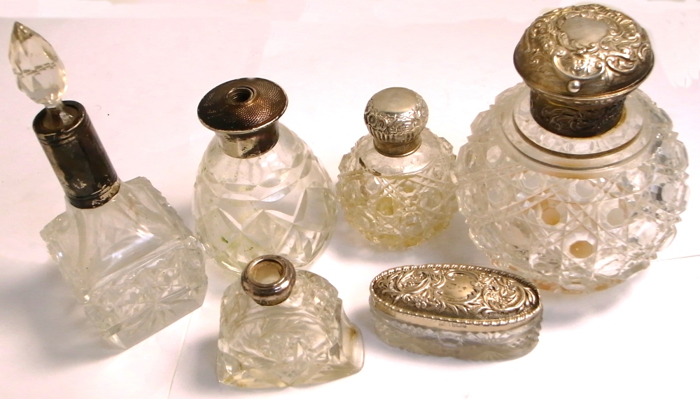 A small hallmarked silver and glass dressing table pot and five perfume bottles with hallmarked