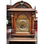 A late 19th century walnut dome top mantel clock, gilded dial set with Arabic numerals, height 42cm.