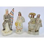 Three late 19th century Staffordshire figures, one depicting a couple with a woman carrying a basket