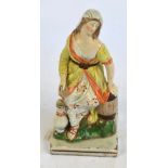 An early 19th century Staffordshire figure of a woman water carrier with a ewer to her side, on