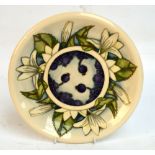A small modern Moorcroft charger in "Juneberry" pattern, designed by Anji Davenport, with