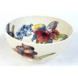 A Moorcroft "Orchid" pattern bowl with tubelined decoration on a cream ground, bearing a sticker and
