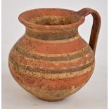 A 5th century Daunian pottery banded jug decorated in red and black earth colours, height 12.5cm.