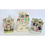 Three late 19th century Staffordshire watch holders figure groups, one depicting a couple with a