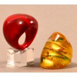 CLARE AUSTIN; two glass rings; red, ring size Q; yellow green and gold, ring size P (2).