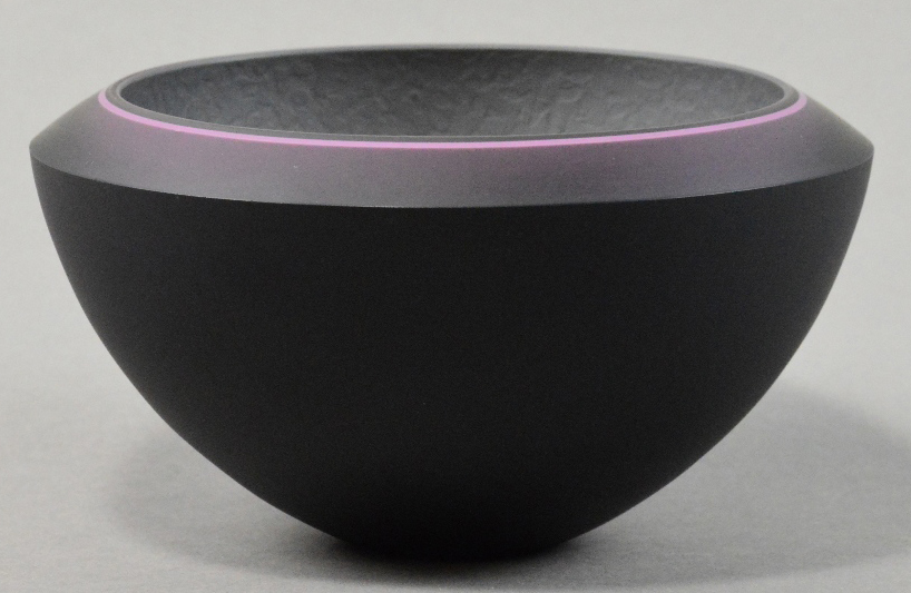 RACHAEL WOODMAN (born 1957); a bevelled glass bowl, black and grey with luminous pink, incised