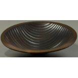 ALEX BROGDEN (born 1954); a double skinned copper 'Wave' footed bowl, fluted with wavy lines,