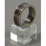 JOEL DEGEN (born 1944); a ring, stainless steel and titanium combined with 18ct gold, ring size Q.