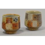 SARAH WALTON (born 1945); a pair of salt glazed footed yunomis, checkerboard decoration, impressed